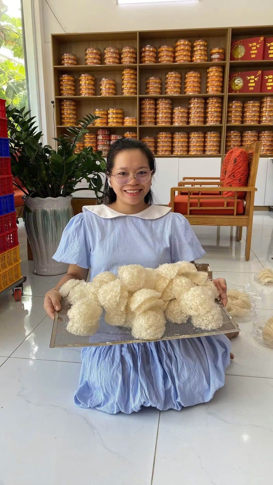 Ngô Thị Cẩm Phượng bên khay tổ yến tinh chế tại cơ sở Nha Trang, Khánh Hòa